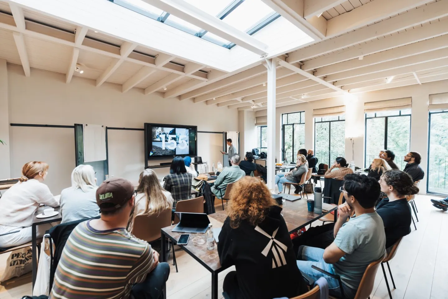 Adults attending a workshop presentation in a light-filled room